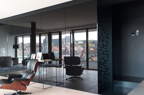 Moderner Treppenaufgang mit Fensterfront und stilvollem Mobiliar in einem eleganten Raum mit Stadtblick.