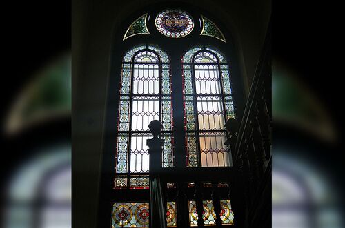 Buntglasfenster einer Gründerzeitvilla, das farbenfrohes Licht in den Raum strömt.