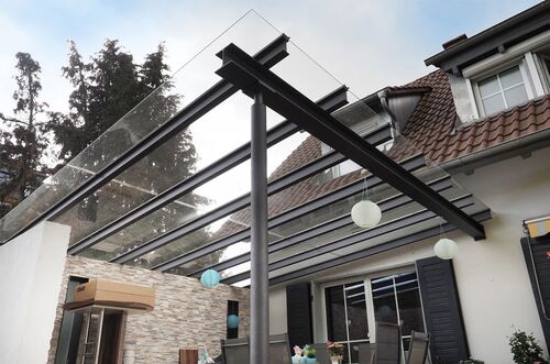 Moderne Terrassenüberdachung mit Glas und Holz, ideal für gemütliche Außenbereiche und entspannte Abende.